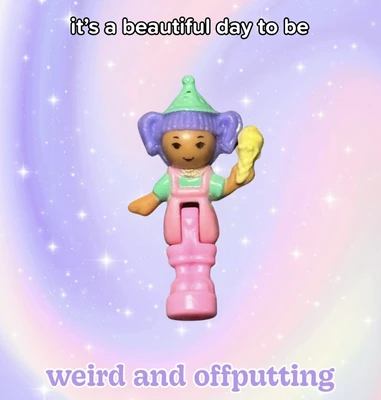 A small brown-skinned toy character stands centered against a pastel lavender, pink, and blue gradient background filled with white sparkles. The character has a simple smiling face, purple hair styled in two large side sections, and a green pointed hat; it wears a green shirt under pink overalls and holds a yellow cone-shaped object in its raised right hand, while its left arm extends outward. The character is attached to or emerging from a tall pink cylindrical base. White text with black outlines at the top reads, “it’s a beautiful day to be”; large lavender text with a white outline at the bottom reads, “weird and offputting”.