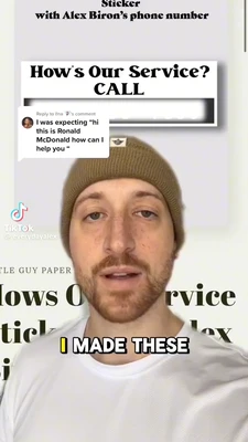 A vertical TikTok frame shows a light-skinned bearded man centered in close-up, wearing a brown knit beanie and a white T-shirt, with a neutral, slightly open-mouthed expression. At the top, black text reads “Sticker” and “with Alex Biron's phone number.” Behind him is a large white sign reading “How’s Our Service? CALL,” followed by a horizontally blurred or obscured phone number. A white comment bubble at upper left reads, “I was expressing ‘hi this is Ronald McDonald how can I help you’”; its header begins “Reply to lna …’s comment.” The TikTok watermark and handle “@everydayalex” appear on the left. Large partially obscured background lettering includes “...TLE GUY PAPER,” “...lows O...rvice,” and “...ticle ... lox.” A bold bottom caption reads “I MADE THESE,” with “I” highlighted in yellow and the remaining words in white with black outlines. This meme is a video; captions are not available.